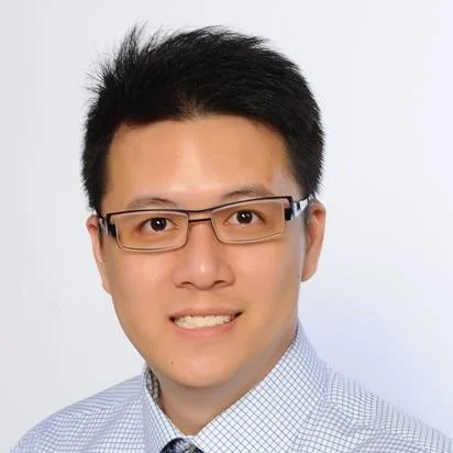 Head-and-shoulders photo of Isaac Fang, wearing glasses and a checked shirt