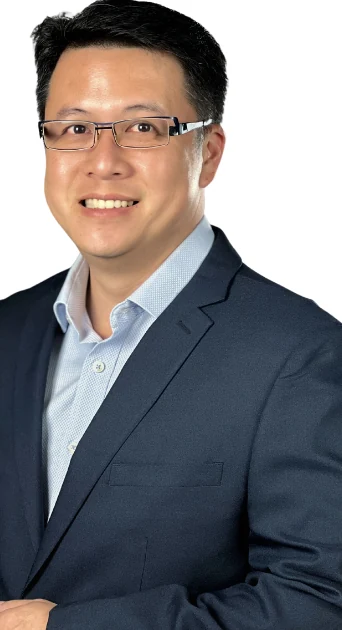Isaac Fang in a navy suit and light blue shirt, smiling